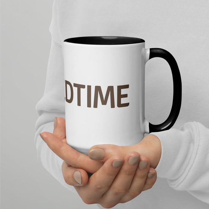 White ceramic mug with black handle and interior, featuring brown "DTIME" text, held by hands in a white sweater.