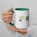 White ceramic mug with green handle, sprout seed logo, and partial "SEED" text, held by hands. Great for coffee or tea.