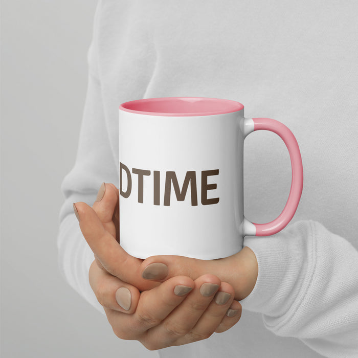 Person holding a white ceramic mug with pink handle & rim, displaying "DTIME" in brown text. Cozy coffee or tea cup.