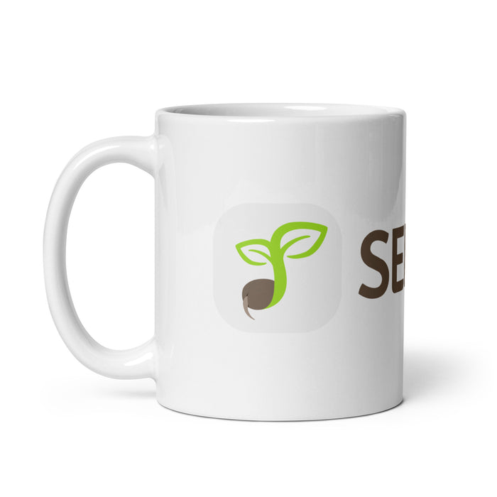 White coffee mug featuring a green sprouting seed logo and partial "SEED" text.