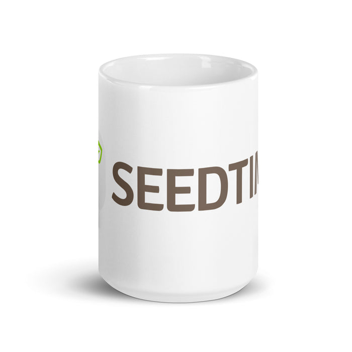 White ceramic coffee mug with "SEEDTIME" in brown text and a green sprout logo. Ideal for gardeners or inspirational gifts.