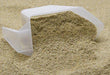 Clear plastic scoop with light brown granular powder spilling. Protein, dietary supplement, fitness ingredient.