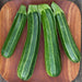 Four fresh green striped zucchini vegetables on a rustic wooden board. Organic summer squash produce.