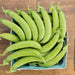 Fresh green sugar snap peas in a light blue paper tray on a rustic wooden table.