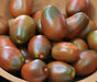 Bowl of ripe black heirloom tomatoes, dark red with green shoulders. Fresh garden produce.