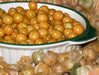 Vibrant golden berries (physalis, cape gooseberries) in a white bowl, with husks in the foreground.