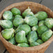 Fresh green Brussels sprouts overflowing a woven basket. Healthy seasonal vegetables, garden harvest.