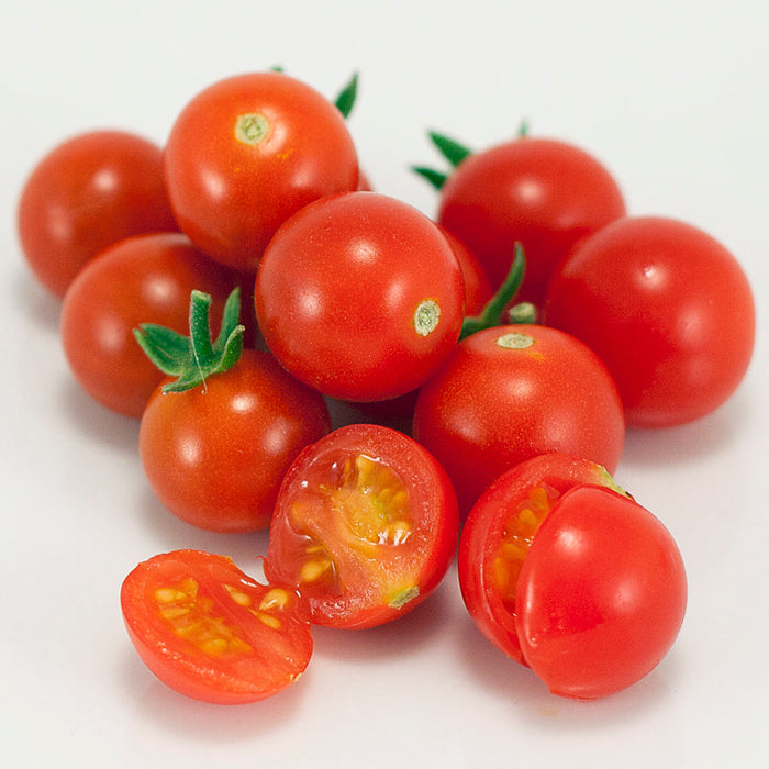 Vibrant red cherry tomatoes, whole and sliced. Fresh, ripe, and juicy for healthy recipes.