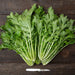 Two bunches of fresh, vibrant green Mizuna Japanese mustard greens on dark wood, with a small knife.